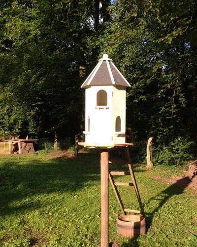 Antikas Futterstation Eleganter Taubenschlag aus stabilen Holz - Näpfe & Futterautomaten, sechseckiges Design für eine stilvolle Fütterung von Tauben im Garten.
